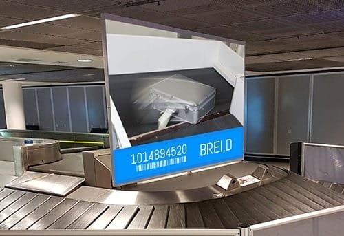 Suitcase on luggage carousel with barcode label BREI D 101489520.