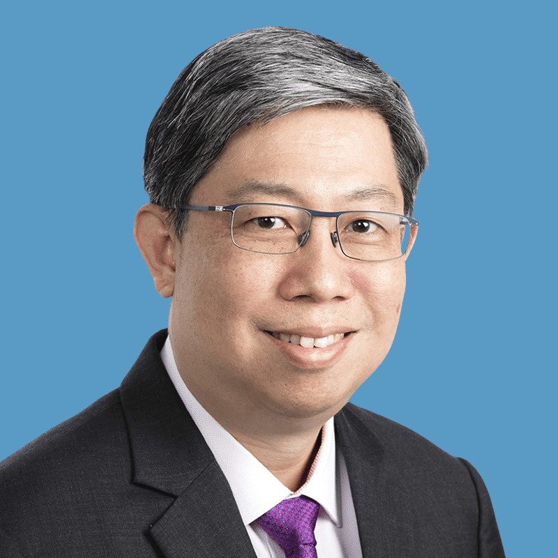 A smiling man with glasses wearing a suit and tie.