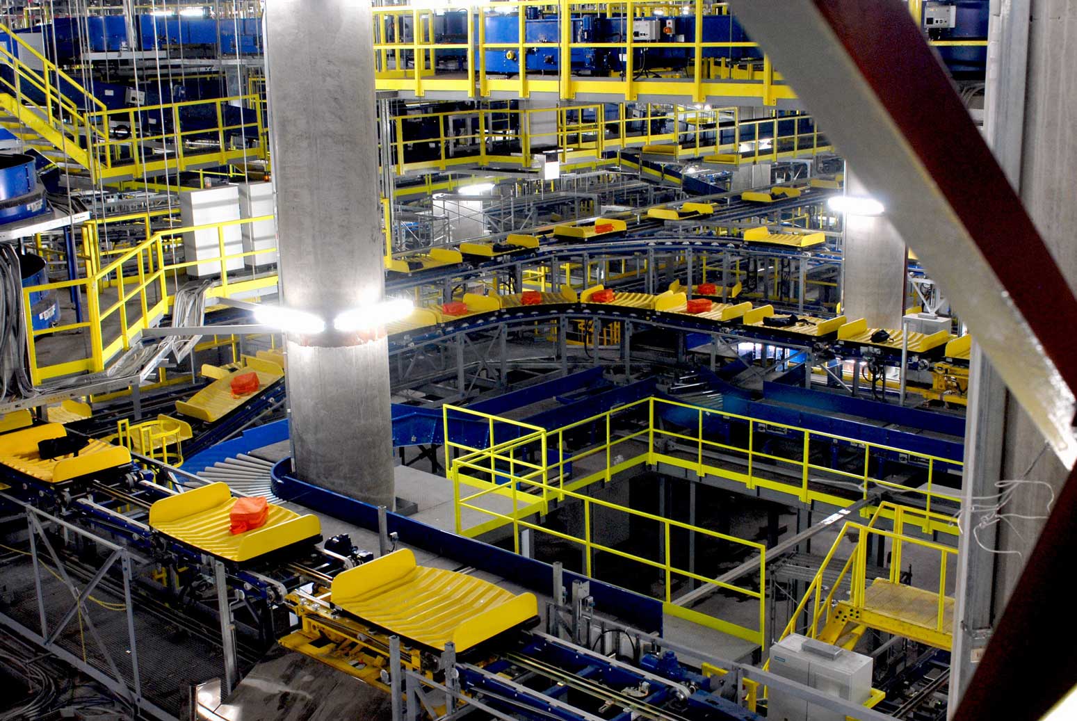 Industrial factory interior with complex machinery and yellow safety structures.